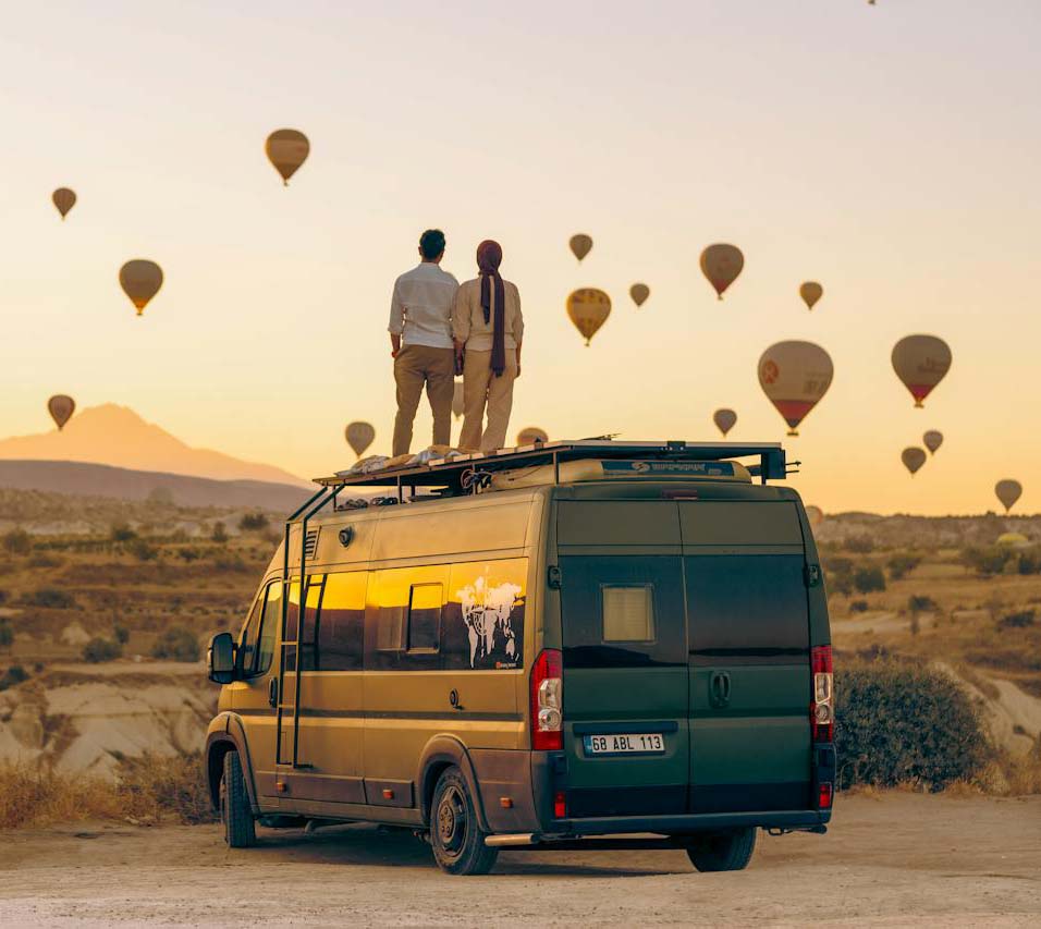 RV van with couple standing on top