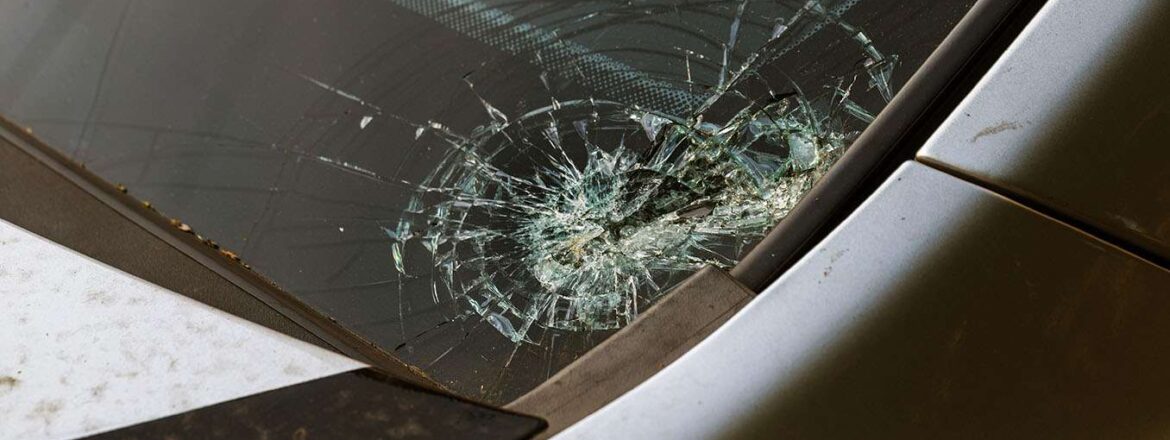 Broken car windshield. Stones on a dirty road from under the wheels at a speed smash car glass. Criminal incidents. Vandals, hooligans mutilated the car, smashed the windshield